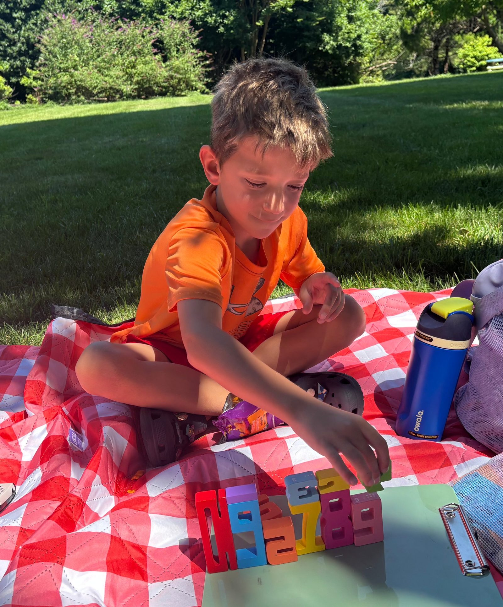Student sequencing number blocks outdoors